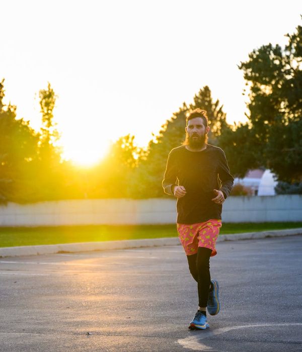 Silhouette of a man stretching against a sunrise, symbolizing vitality and energy.